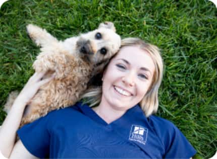 women lying on the grass with dog